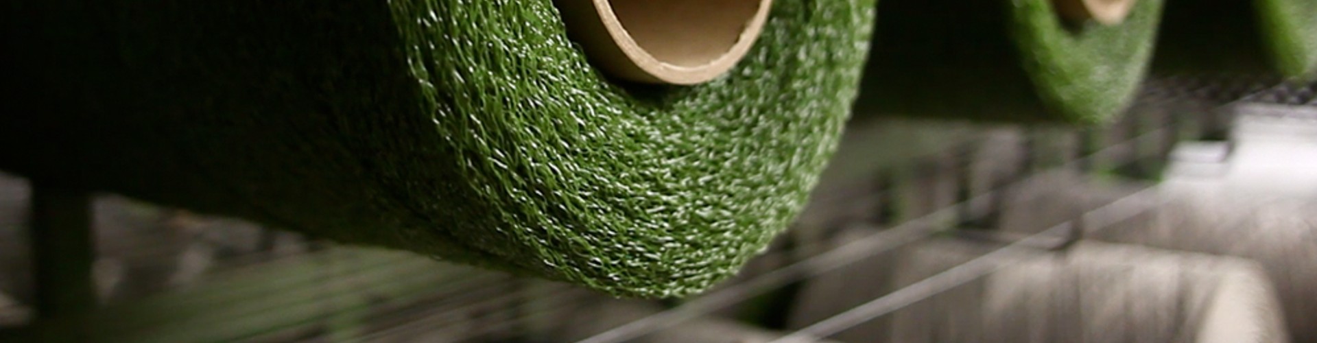 Synthetic turf installation process showing green artificial grass roll being secured for use on a prepared base for a durable, low-maintenance lawn.