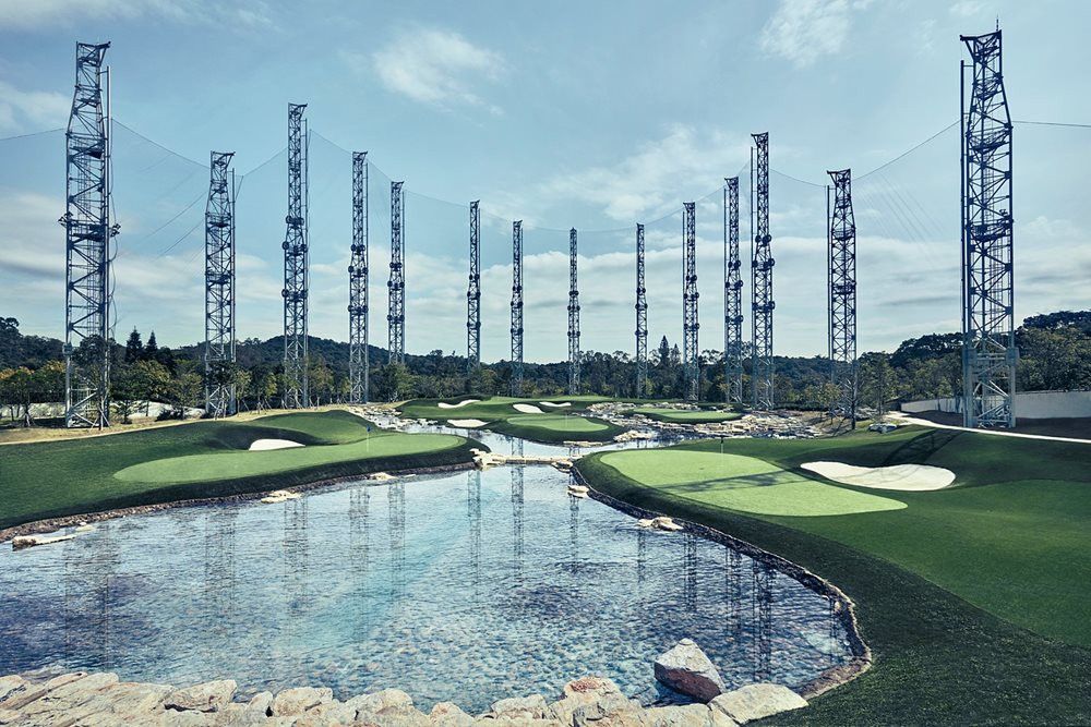 Oakley Synthetic grass golf course with water and tall metal towers