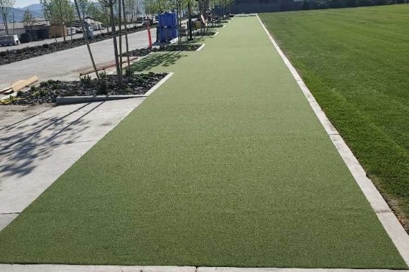 Oakley Outdoor tee line consisting of one continuous green synthetic grass strip surrounded by trees